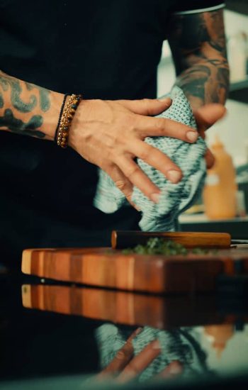 Chef wiping down a wooden chopping board